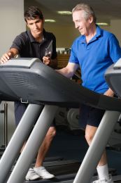 A cardiac rehabilitation program is designed to meet your needs. Athletic trainer helps man who is on a treadmill